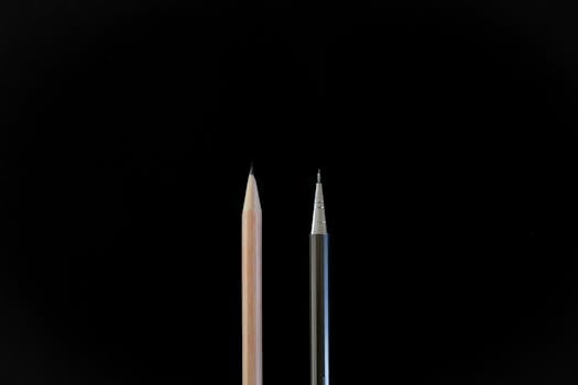 A clean, minimalist shot showcasing a traditional pencil and a mechanical pencil against a black background.