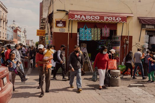 Lively street scene in Puebla, Mexico, capturing urban life with people shopping and walking.