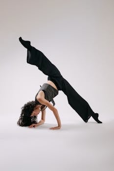 A dynamic dancer performs an impressive handstand in a minimalist studio.